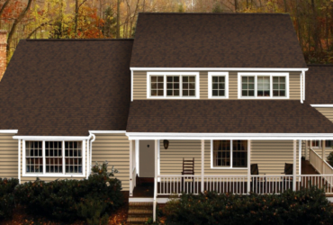 Siding Contractors St Paul MN - A Brown and Tan House with Autumn Colors Behind it