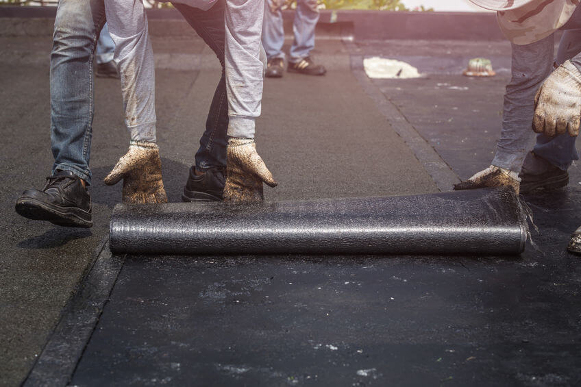 EPDM Roof Installation - A Black Roof Being Rolled On
