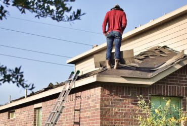 A man standing on a roof that needs replacement