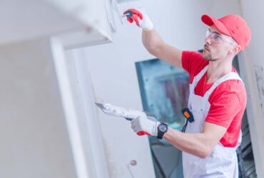 Basement Remodel St Paul - A Man Applying Plaster to Wall