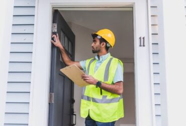 Home inspector at work checking out the exterior of a house.