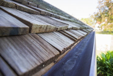 How Often Should Gutters be Cleaned? - A Picture of a Roof's Edge with Rain Gutters Showing