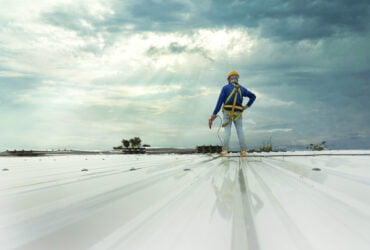 Commercial Roof Repair Minneapolis, MN - A Roofer Standing on a New Metal Roof