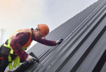 Minneapolis Commercial Roofing Contractors: A Man Installing a Corrugated Metal Roof