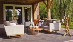 Ideas for Maximizing Your Outdoor Living Space After Moving to a New Home Two women sitting on a sofa on their patio while one plays the guitar.