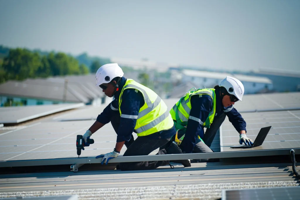 About Us - Two Roofers Working on a Metal Roof
