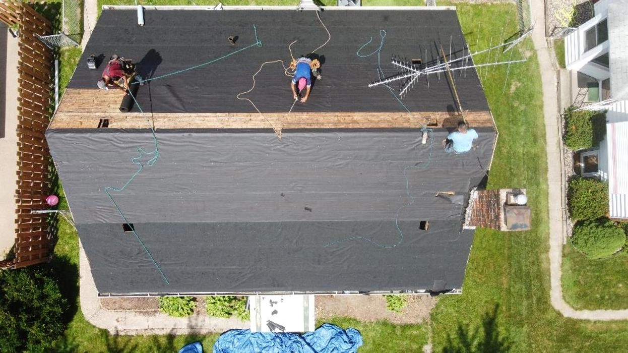 Aerial view of a Sellers Roofing crew installing a low-slope roof