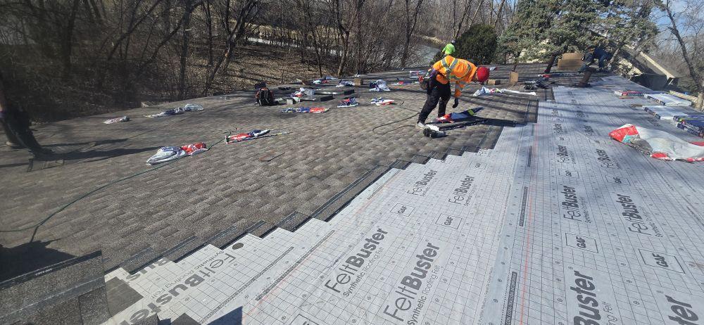 GAF FeltBuster synthetic underlayment installation by Sellers Roofing crew member in fall arrest gear — Saint Paul, MN residential roof replacement