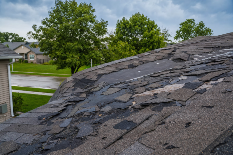 Storm-damaged roof on a Coon Rapids, MN home — torn shingles and debris after a Minnesota thunderstorm