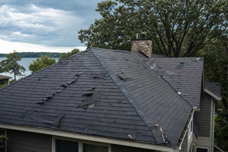 Storm-damaged roof on a White Bear Lake, MN home — torn shingles and debris after a Minnesota thunderstorm