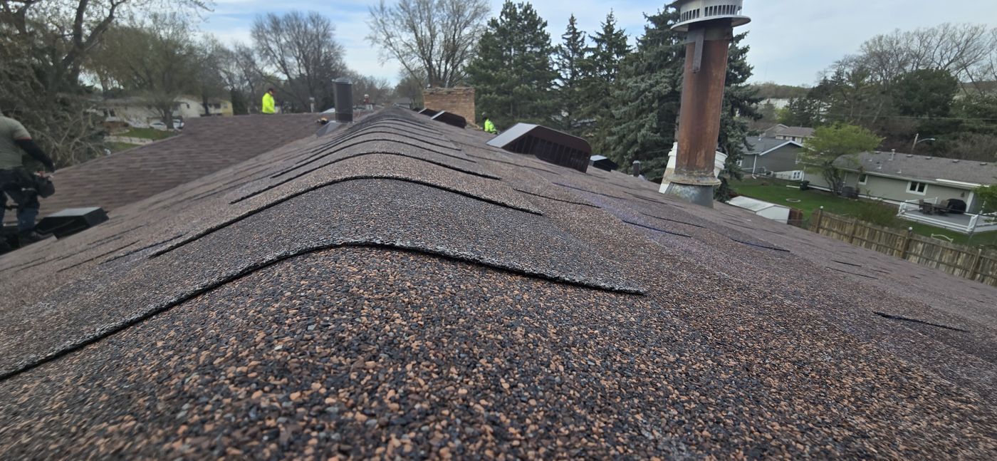 Commercial & Residential Roofing in Saint Paul, MN | Sellers Roofing Worn asphalt shingle ridge documented during a Sellers Roofing inspection before roof replacement in New Brighton, MN
