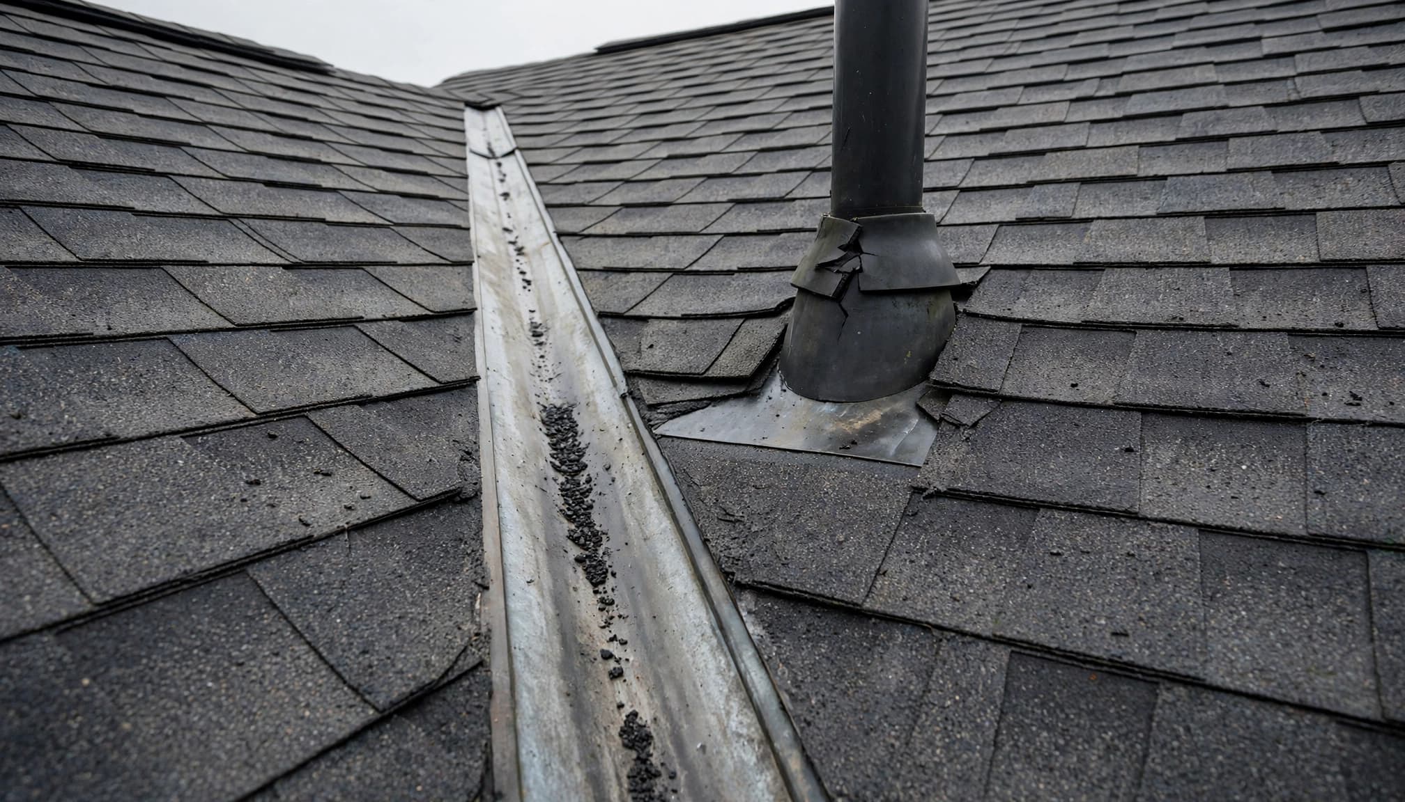 Why Does a Minnesota Roof Leak Only in Short, Heavy Rain? Minnesota roof leak inspection after heavy rain showing valley flashing and a cracked pipe boot.