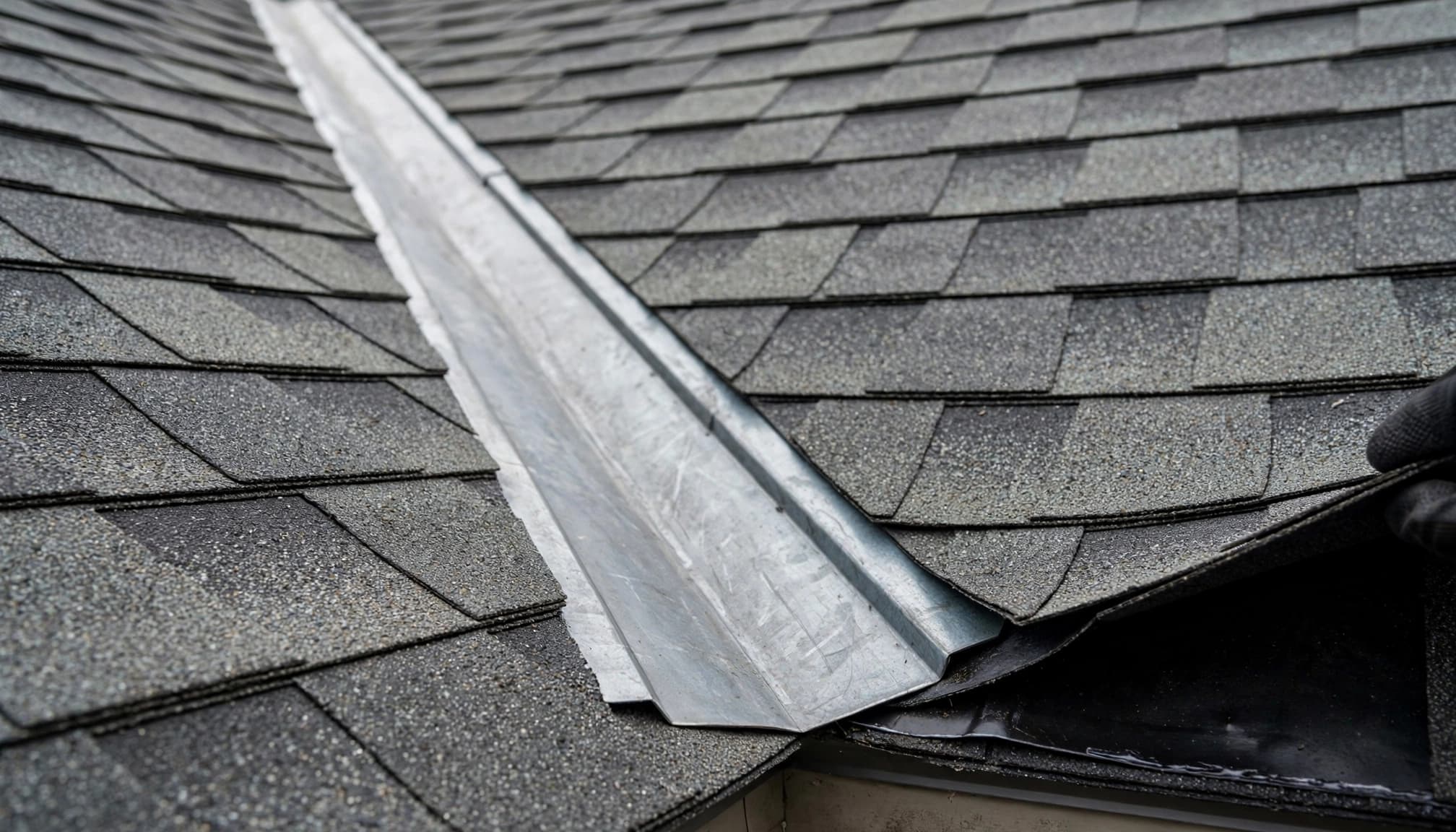 Can Freeze-Thaw Open Gaps Between Asphalt Shingle Courses? Valley flashing and overlapping asphalt shingles during a Minnesota roof inspection